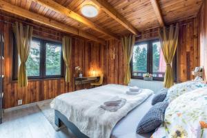 a bedroom with a bed in a room with wooden walls at Anna Sela in Vrbov