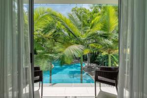 a view of a swimming pool from a window at Bougainvillea - Beachside Luxury at The Drift in Palm Cove