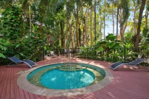 a swimming pool in the middle of a garden at Bougainvillea - Beachside Luxury at The Drift in Palm Cove
