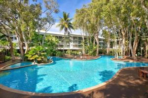a large pool with trees in front of a building at Bougainvillea - Beachside Luxury at The Drift in Palm Cove