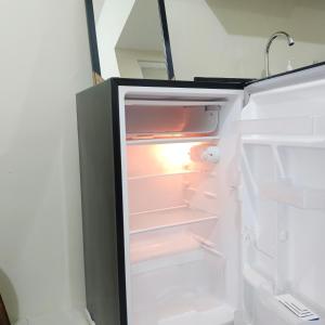 an open refrigerator with its door open and its contents at Unit 208 Venus Transients-Brenthill in Baguio
