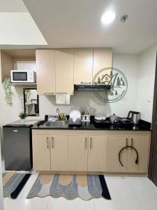 a kitchen with wooden cabinets and a sink at Unit 208 Venus Transients-Brenthill in Baguio +5 photos