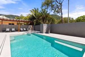 a swimming pool in the backyard of a house at Raphari At The Cove - A Stunning Poolside Escape in Palm Cove