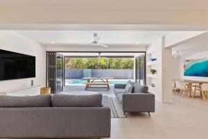 a living room with a couch and a table at Raphari At The Cove - A Stunning Poolside Escape in Palm Cove