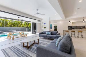 a living room with a couch and a table at Raphari At The Cove - A Stunning Poolside Escape in Palm Cove +30 photos