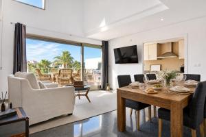 a living room with a wooden table and chairs at Exquisite Costa Blanca Escape Townhouses in El Campello