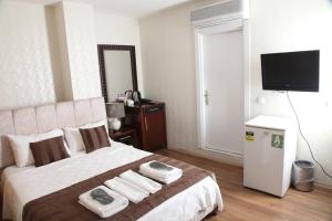 a bedroom with a large bed with towels on it at Çamlıca Tower Hotel in Istanbul