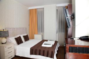 a bedroom with a bed and a desk and a television at Çamlıca Tower Hotel in Istanbul