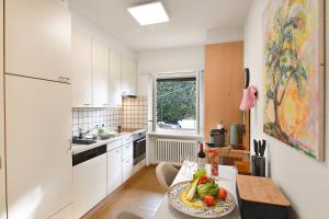 a kitchen with a table with a plate of fruit on it at Ca' Lidia - Lugano Villa with Garden and Parking - Happy Rentals in Pregassona
