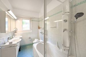 a bathroom with a tub and a sink and a shower at Ca' Lidia - Lugano Villa with Garden and Parking - Happy Rentals in Pregassona