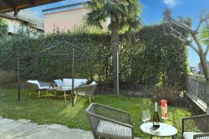 a backyard with a table and chairs and a fence at Ca' Lidia - Lugano Villa with Garden and Parking - Happy Rentals in Pregassona +14 photos