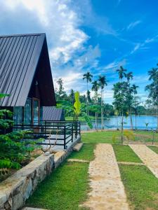 a house on the shore of a body of water at Jungle Lake View Cabana in Udawalawe