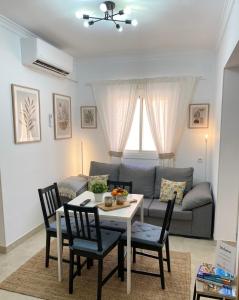 a living room with a table and chairs and a couch at Apartamentos SOL y ARENA in Almería