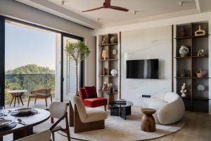 a living room with a table and chairs and a ceiling fan at Southbeach Weligama in Weligama
