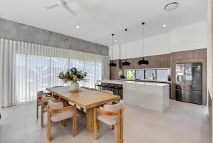 a kitchen with a wooden table and chairs at Salt - Beachfront Luxe with Private Pool in Palm Cove