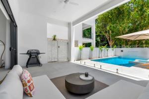 a living room with a pool and a large window at Salt - Beachfront Luxe with Private Pool in Palm Cove