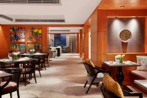 a restaurant with tables and chairs in a room at Mandarin Oriental, Kuala Lumpur in Kuala Lumpur
