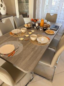 a dining room table with plates and food on it at Entre Loire et Zoo Chambres d hôtes in Meusnes