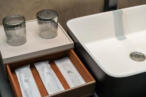 a drawer with two glass jars and a sink at 德全m酒店 in Beijing