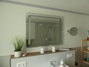 a bathroom with a large mirror above a sink at Ferienwohnung Sünteltraum in Hameln +25 photos
