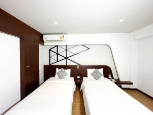 zwei Einzelbetten in einem Zimmer mit Heizung in der Unterkunft Coco Hotel in Bangkok