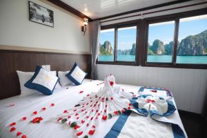 a bedroom with a bed with red and white flowers on it at Sunlight Legend Cruise in Ha Long