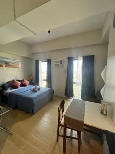 a bedroom with a bed and a table in it at Studiocuarto Cebu Hub in Mandaue City