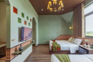 a bedroom with a bed and a flat screen tv at 68 Hotel Go Cong in Gò Công
