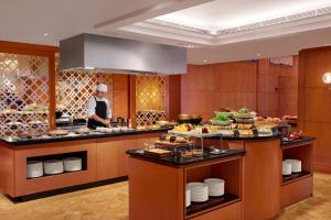 a chef preparing food in a hotel kitchen at Mandarin Oriental, Kuala Lumpur in Kuala Lumpur +64 photos