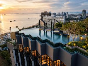 a pool on top of a building with a view of the water at The Edge central pattaya in Pattaya