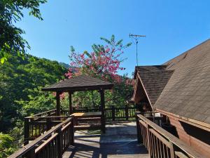 a wooden gazebo with a bench on a bridge at Beauty House in Nanzhuang
