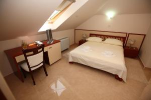 a bedroom with a bed and a desk with a television at Hotel Trogir Palace in Trogir