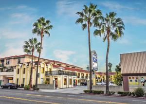 a street with palm trees in front of a building at Chariot Inn Glendale - Pasadena in Glendale