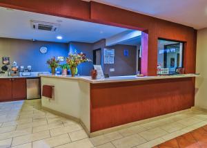 a waiting room with a counter with flowers on it at Chariot Inn Glendale - Pasadena in Glendale