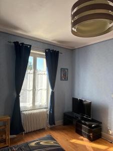 a living room with a tv and a window at Entre Loire et Zoo Chambres d hôtes in Meusnes