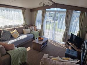 a living room with a couch and a tv at Durdlee Door, D27, Main Rd, West Lulworth, Wareham BH20 5PU in West Lulworth