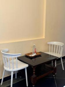 a table with two chairs and a bottle of water on it at Serenity Beach Inn in Pondicherry