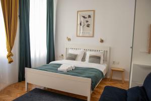 a bedroom with a white bed with a green blanket at Studio Old Town with Jacuzzi and View in Bucharest
