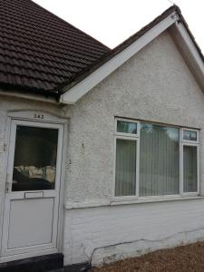 a house with a white door and two windows at The Tushmore in Crawley