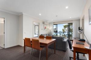 a living room with a table and a couch at Bayside Geelong Hotel & Apartments, an Ascend Collection Hotel in Geelong