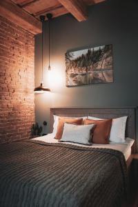 a bedroom with a bed with a painting on the wall at Apartment No 14 in Līgatne