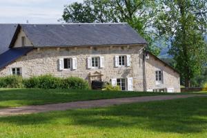 a stone house with a black roof at Le Château D'orfeuillette in La Garde