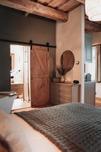 a bedroom with a bed with a wooden door and a mirror at Apartment No 14 in Līgatne