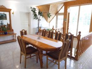 a dining room with a wooden table and chairs at Millennium Villa in Keszthely