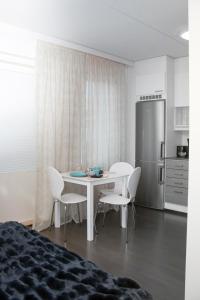 a kitchen with a table and chairs and a refrigerator at Lahti Center House in Lahti