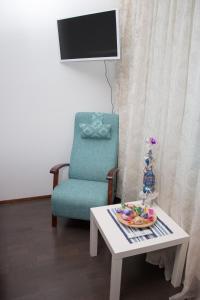 uma sala de estar com uma cadeira azul e uma mesa em Lahti Center House em Lahti
