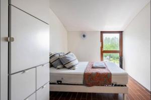 a white room with a bed with a window at Hop zanzibar 1 in Belmont-sur-Lausanne