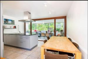 a kitchen and dining room with a wooden table at Hop zanzibar 1 in Belmont-sur-Lausanne