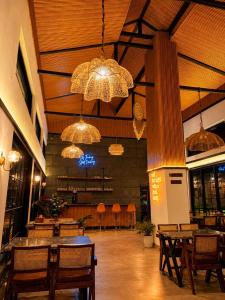 a restaurant with tables and chairs and chandeliers at Tiraya Luxury Riverside Hotel & Café in Gushaini