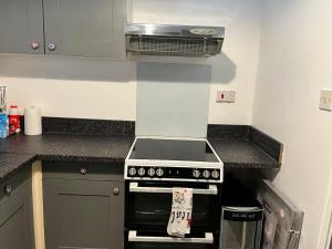 a kitchen with a stove and a counter top at Accessible Flat Bedford in Bedford